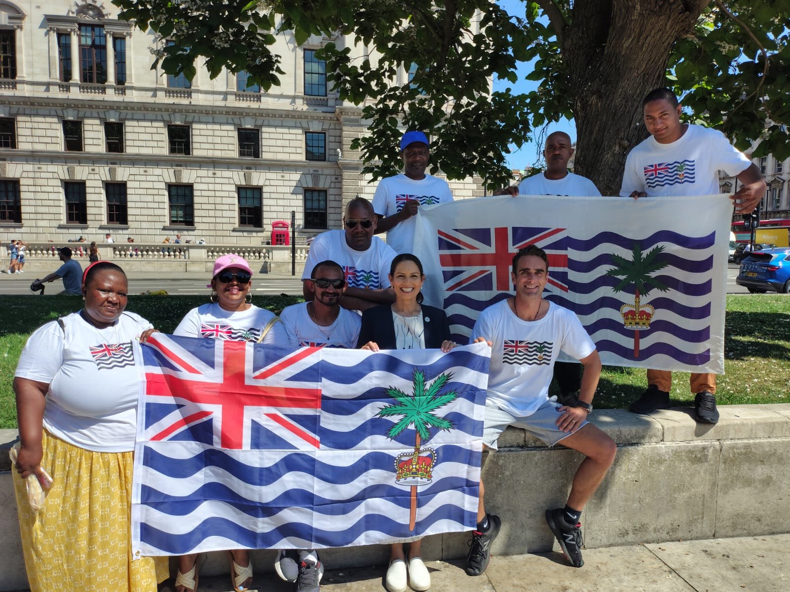 Dame Priti Patel standing with Chagossian campaigners